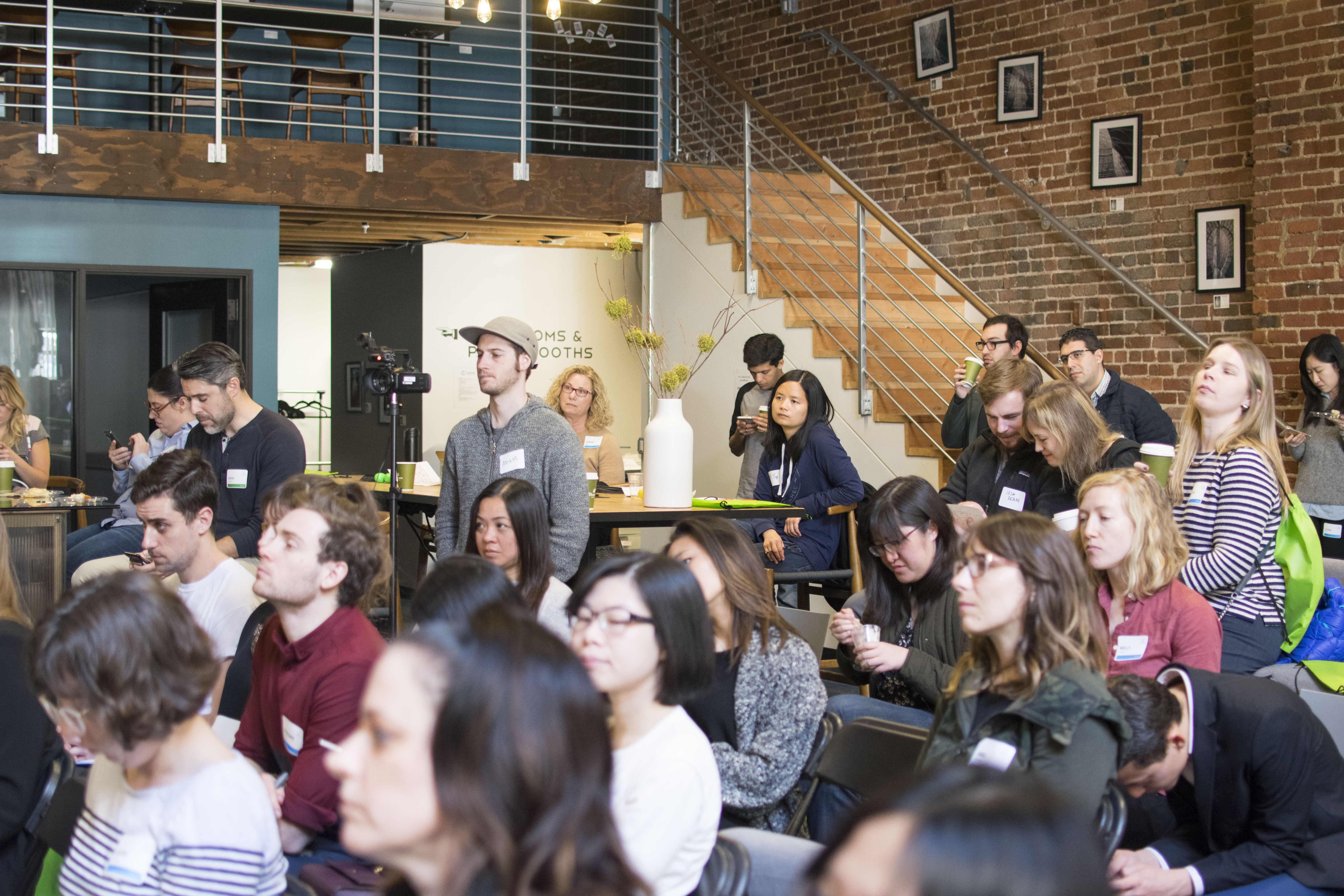 Attendees taking notes at WIAD17 Seattle with event volunteers in the background