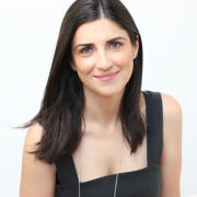 A headshot of Maria; straight dark brown hair and a black dress.