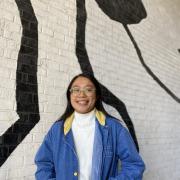 Speaker Shannon Li, woman with hands in her pocket standing in front of a white and black wall. 