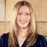 Photo of a white woman with long light brown blonde hair and dark top