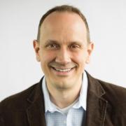 Profile image of a white man with short hair, button up and jacket. 