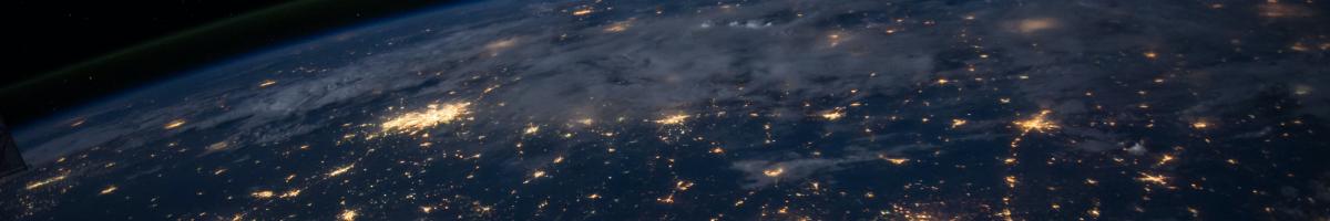 Zoomed out image from space, dark earth with lit up cities